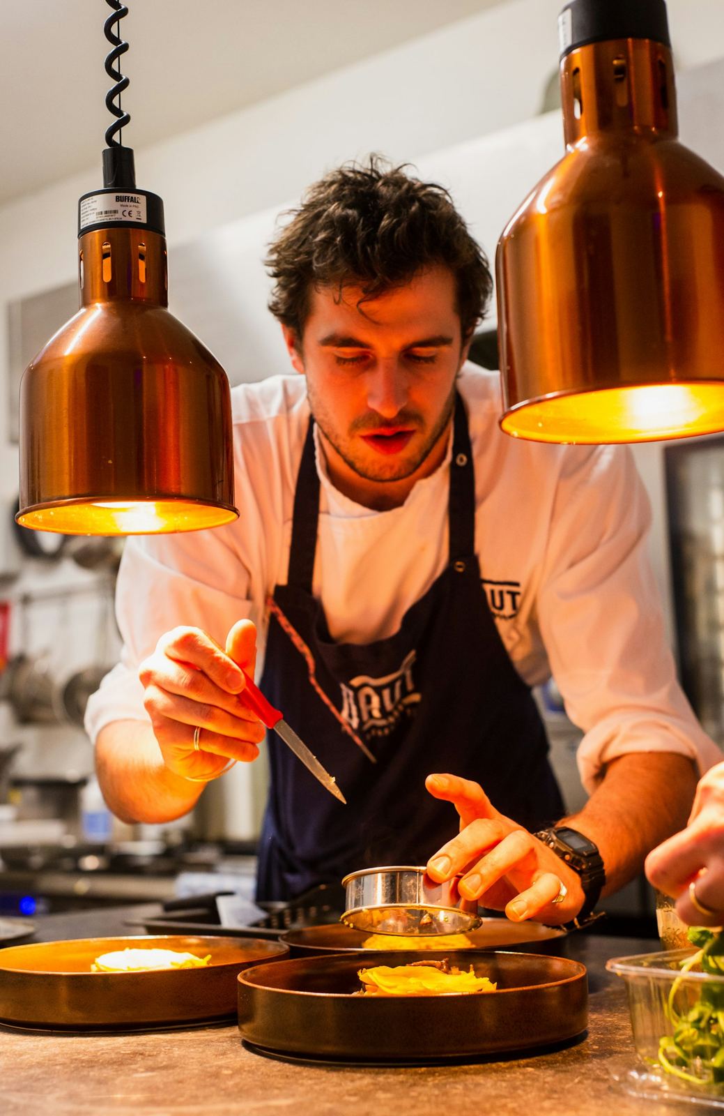 Cuoco al banco di una cucina professionale